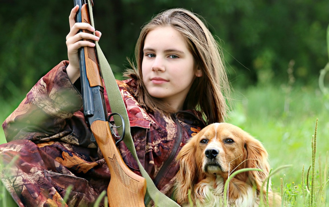 Girl with gun and dog